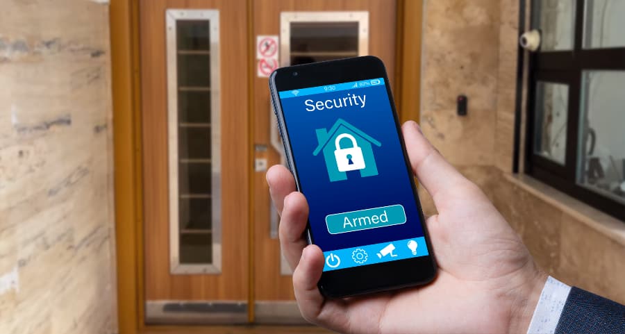 Person using smartphone to arm a security system